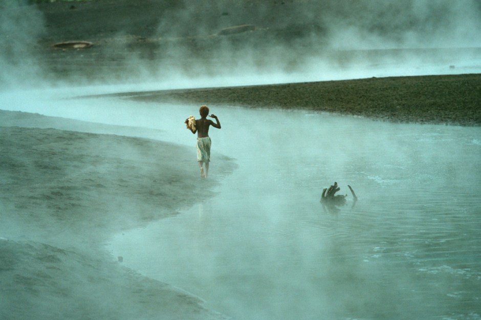 Vanuatu, Tanna Island, 1999On the island of Tanna in Vanuatu a cargo cult still survives worshipping John Frum.On John Frum Day worshipers dress in USA military uniforms,raise the US flag, and parade marching with bamboo rifles.Photo shows a young boy walking along the banks of a heated stream in Sulphur Bay which is a village that worships John Frum . Vanuatu, L'Óle Tanna, 1999Sur l'Óle de Tanna ‡ Vanuatu un cargo de lÈgende existe toujours en mÈmoire ‡ John Frum.Le jour de John Frum, les fidËles s'habillent en tenue militaire de l'armÈe amÈricaine, ils hissent le drapeau, et font des parades avec des carabines en bambou. La photo montre un jeune garÁon marchant le long de vapeurs chaudes ‡ Sulphur Bay, le village o˘ est cÈlÈbrÈ John Frum.Steven Siewert / Agence VU