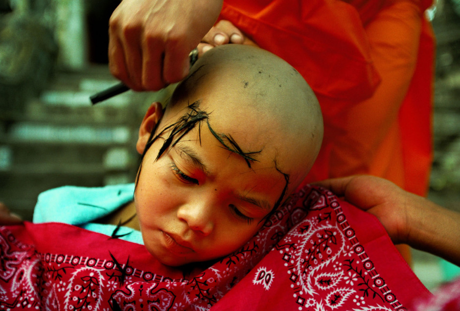 Thailand, Chiang Mai, 2002Shan Buddist Ceremony for young novice monks held at WatPa Pao in Chiang Mai,north-western Thailand.The ceremony takes place over three days where children are dressed up with lavish clothing and bright makeup and carried on the shoulders of family members.Here a young novice has his head shaved by monks before the start of the ceremony.Thailande, Chiang Mai, 2002Une cÈrÈmonie bouddhiste Shan pour les nouveaux moines se passe au temple WatPa Pao ‡ Chiang Mai, au Nord-Ouest de la Thailande. La cÈrÈmonie dure 3 jours et les enfants sont habillÈs de vÍtements lourds, sont maquillÈs avec des couleurs voyantes et sont portÈs sur les Èpaules des membres de leur famille. Les moines rasent les cheveux de ce jeunes novice avant le dÈbut de la cÈrÈmonie.Steven Siewert / Agence VU