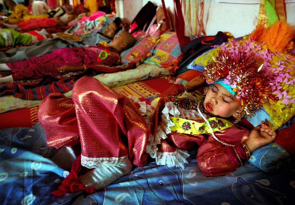 Thailand, Chiang Mai, 2002Shan Buddist Ceremony for young novice monks held at WatPa Pao in Chiang Mai,north-western Thailand.The ceremony takes place over three days where children are dressed up with lavish clothing and bright makeup and carried on the shoulders of family members.Photo shows a young novices monk sleeping during a busy day of parades .Thailande, Chiang Mai, 2002Une cÈrÈmonie bouddhiste Shan pour les nouveaux moines se passe au temple WatPa Pao ‡ Chiang Mai, au Nord-Ouest de la Thailande. La cÈrÈmonie dure 3 jours et les enfants sont habillÈs de vÍtements lourds, sont maquillÈs avec des couleurs voyantes et sont portÈs sur les Èpaules des membres de leur famille. Un jeune moine novice est en train de dormir lors d'une longue journÈe de dÈfilÈs.Steven Siewert / Agence VU