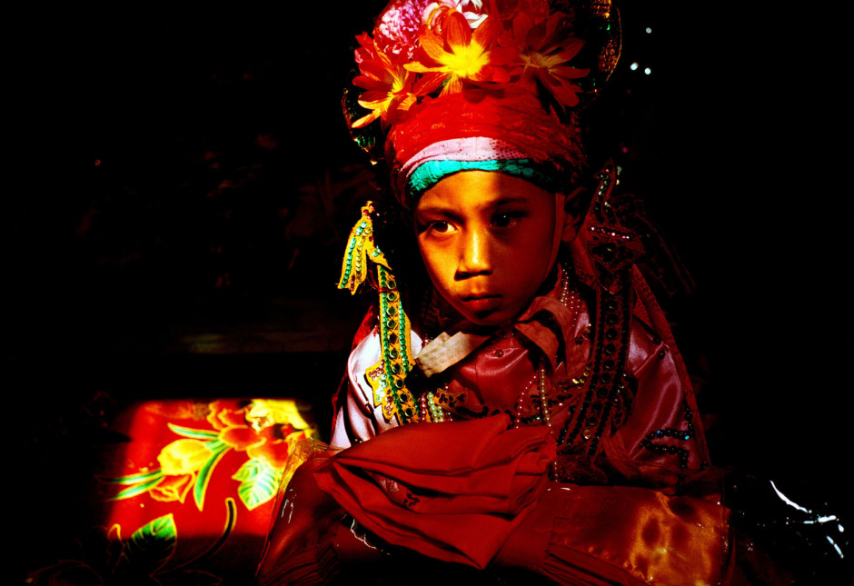 Thailand, Chiang Mai, 2002Shan Buddist Ceremony for young novice monks held at WatPa Pao in Chiang Mai,north-western Thailand.The ceremony takes place over three days where children are dressed up with lavish clothing and bright makeup and carried on the shoulders of family members.Photo shows a young novice monk with his last moments in the elaborate clothing before changing into saffron robes during the ceremony.Thailande, Chiang Mai, 2002Une cÈrÈmonie bouddhiste Shan pour les nouveaux moines se passe au temple WatPa Pao ‡ Chiang Mai, au Nord-Ouest de la Thailande. La cÈrÈmonie dure 3 jours et les enfants sont habillÈs de vÍtements lourds, sont maquillÈs avec des couleurs voyantes et sont portÈs sur les Èpaules des membres de leur famille. Un jeune moine novice vÍtu pour peu de temps encore du costume ÈlaborÈ avant de vÍtir une robe saffranÈe pendant la cÈrÈmonie.Steven Siewert / Agence VU