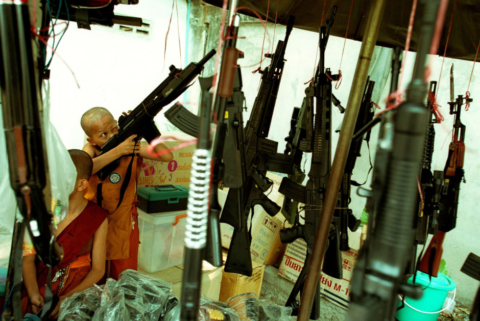 Thailand, Chiang Mai, 2002Shan Buddist Ceremony for young novice monks held at WatPa Pao in Chiang Mai,north-western Thailand.The ceremony takes place over three days where children are dressed up with lavish clothing and bright makeup and carried on the shoulders of family members.Photo shows a young novice monks in saffron robes playing with toy guns after the ceremony.Thailande, Chiang Mai, 2002Une cÈrÈmonie bouddhiste Shan pour les nouveaux moines se passe au temple WatPa Pao ‡ Chiang Mai, au Nord-Ouest de la Thailande. La cÈrÈmonie dure 3 jours et les enfants sont habillÈs de vÍtements lourds, sont maquillÈs avec des couleurs voyantes et sont portÈs sur les Èpaules des membres de leur famille. Un jeune moine novice vÍtu d'une robe saffranÈe joue avec une arme en plastique aprËs la cÈrÈmonie.Steven Siewert / Agence VU