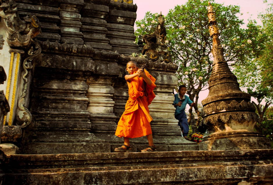 Thailand, Chiang Mai, 2002Shan Buddist Ceremony for young novice monks held at WatPa Pao in Chiang Mai,north-western Thailand.The ceremony takes place over three days where children are dressed up with lavish clothing and bright makeup and carried on the shoulders of family members.Photo shows a young novice monks in saffron robes playing with toy guns after the ceremony.Thailande, Chiang Mai, 2002Une cÈrÈmonie bouddhiste Shan pour les nouveaux moines se passe au temple WatPa Pao ‡ Chiang Mai, au Nord-Ouest de la Thailande. La cÈrÈmonie dure 3 jours et les enfants sont habillÈs de vÍtements lourds, sont maquillÈs avec des couleurs voyantes et sont portÈs sur les Èpaules des membres de leur famille. Un jeune moine novice vÍtu d'une robe saffranÈe joue avec une arme en plastique aprËs la cÈrÈmonie.Steven Siewert / Agence VU