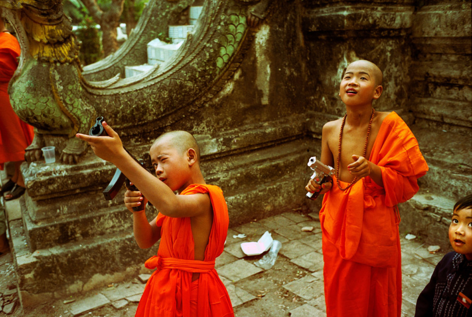Thailand, Chiang Mai, 2002Shan Buddist Ceremony for young novice monks held at WatPa Pao in Chiang Mai,north-western Thailand.The ceremony takes place over three days where children are dressed up with lavish clothing and bright makeup and carried on the shoulders of family members.Photo shows a young novice monks in saffron robes playing with toy guns after the ceremony.Thailande, Chiang Mai, 2002Une cÈrÈmonie bouddhiste Shan pour les nouveaux moines se passe au temple WatPa Pao ‡ Chiang Mai, au Nord-Ouest de la Thailande. La cÈrÈmonie dure 3 jours et les enfants sont habillÈs de vÍtements lourds, sont maquillÈs avec des couleurs voyantes et sont portÈs sur les Èpaules des membres de leur famille. Un jeune moine novice vÍtu d'une robe saffranÈe joue avec une arme en plastique aprËs la cÈrÈmonie.Steven Siewert / Agence VU