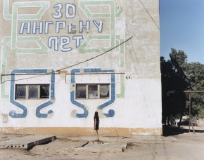 © RIP HOPKINS / AGENCE VUHOME AND AWAYOUZBEKISTAN, 200216/08/02Sveltana Demid in front of an inscription reading : Angren is 30 years old, in the mining town of Angren, 60 kilometres east of Tashkent. She is 21 years old. He is an accountant. Her Russian mother came from Kirgizstan in 1985 and her father's parents came here to build Angren in 1950. She does not know if she will leave.N°10650