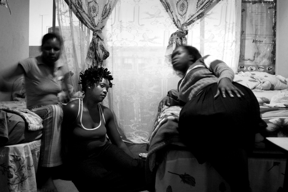 South Africa, April 2004Gloria Marembe has her hair braided by friends in her room in Hillbrow, that she shares with four other women.  Afrique du Sud, DÈcembre 2003Des amis font des nattes ‡ Gloria Marembe dans sa chambre ‡ Hillbrow qu'elle partage avec quatre autres femmes.© Guy Tillim / Agence VU