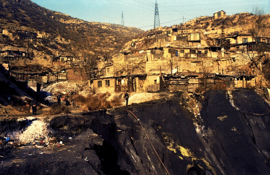 China, Gujiao, 2006
Gujiao, mining city.
The salary of the migrant workers doesn't allow them to build a true house on the side of the 'hole'.  
In the shantytowns with coal-black air and without running water and social protection, breathing deseases spread around and the houses fall down one after the other weakend by the galleries nibbling the mountain from the inside.
"In Mao's time, miners used to be heros. But now we're nothing." Xiu Yu Jun, miner.

Chine, Gujiao, 2006
Gujiao, ville minière.
Le salaire des ouvriers migrants ne leur permet pas de se construire une vraie maison au bord du "trou".
Dans les bidonvilles à l'air charbonneux, sans eau courante et sans protection sociale, les maladies respiratoires prolifèrent et les maisons s'effondrent une à une, fragilisées par les galeries rongeant la montagne de l'intérieur.
Du temps de Mao, en tant que mineur, nous étions des héros, mais aujourd'hui, nous ne sommes plus rien".
Xiu Yu Jun. Mineur.

Samuel Bollendorff / Agence VU