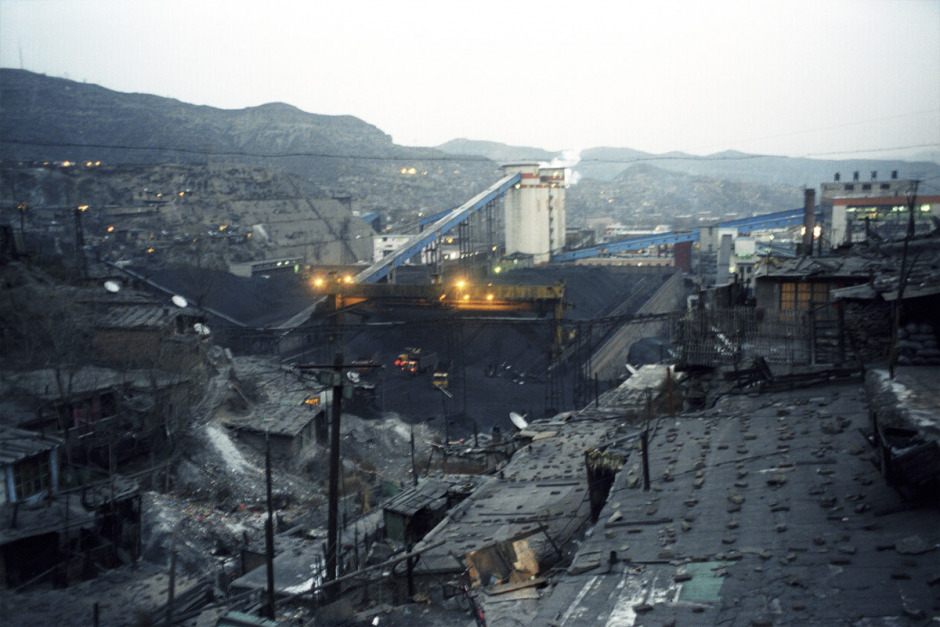 China, Gujiao, 2006 - The coal mine in Gujiao. The mingongs, the worker - farmers coming from the poor region of China go down the mine for 150 euros per month. Not enought to build a real house around the "hole". Without any social protection, without security inside the mine, they are the most exposed to the risk. The pollution of the factories is also a breathing disease factor. Xiu Yu Jun says : "before we were respected as miners, now we are the last on the social rank."