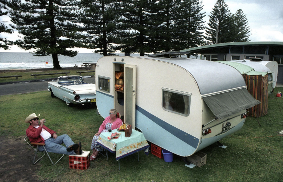 Australia, Sydney, March 2004Waiting for Wanda Jackson.Wayne and Sharon sit outside their 1959 caravan with their Ford Fairlane Skyline Retractable parked in front. They are at Coledale Caravan Park in 2005 for the annual vintage caravan weekend where up to 40 caravans take up position on the edge of the beach. Wayne and Sharon's caravan is completely decked out in 1950s furniture, decorations and knick-knacks.Australie, Sydney, Mars 2004En attendant Wanda Jackson.Wayne et Sharon sont assis devant leur caravane de 1959, leur Ford fairlane Skyline dÈcapotable est garÈe devant. Ils sont au camping de Coledale pour le weekend caravane vintage o˘ plus de 40 caravanes s'installent sur le bord de la plage. La caravane de Wayne et de Sharon est entiËrement refaite avec des meubles des annÈes annÈes 50's (dÈco et bibelots compris).Steven Siewert / Agence VU