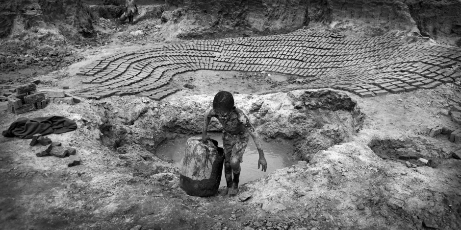 Burundi, Bujumbura, Buhumba bricks production site, November 2011Jean Claude Nkurunziza, 9 years old, is collecting water to make bricks.Jean Claude's mother killed his father after years of beating. She is now in Mpimba prison. Leaving her eight children to look after themselves. The sisters work in the field in order to feed the youngest while the oldest brother doesn't help. Jean Claude lives with his aunt and cousins and has to work 13 hours a day, making 900 to 1000 bricks to earn 1500 burundian francs (about 1.2 US dollar). Just enough to buy him a fritter... Later, he wants to go to school and would become a pilot. Burundi, Bujumbura, fabrique de briques de Buhomba, novembre 2011Jean Claude Nkurunziza, 9 ans, en train de puiser l'eau nÈcessaire ‡ la fabrique des briques.La mËre de Jean Claude a tuÈ son pËre aprËs avoir ÈtÈ battue pendant des annÈes, et est maintenant dÈtenue ‡ la prison de Mpimba. En son absence, ces huit enfants s'en sortent comme ils peuvent. Tandis que les soeurs travaillent dans les champs et parviennent parfois ‡ acheter ‡ manger aux plus petits, l'ainÈ, mariÈ, ne leur vient pas en aide. Jean Claude vit avec sa tante et ses cousins, mais puisque il n'y a pas de quoi nourrir tout le monde, il fabrique 900 ‡ 1000 briques par jour (en travaillant pendant 13 heures) pour gagner la somme de 1500 francs burundais (1.2 dollar US). Juste de quoi s'acheter un beignet... Plus tard, il voudrait aller ‡ l'Ècole pour devenir pilote d'avions.Martina Bacigalupo / Agence VU