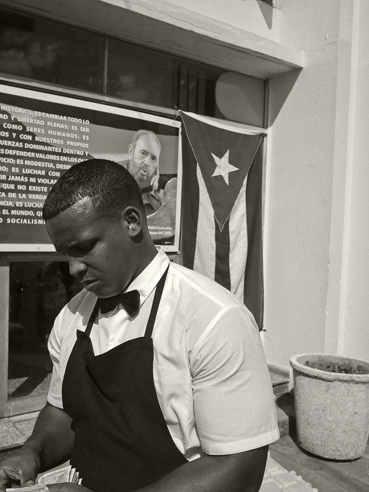 Cuba, Havana, 28 November 2016A water seller on Revolution Square. Behind him, a propaganda text from the Party and a Cuban flag.Cuba, La Havane, 28 novembre 2016Un vendeur d'eau Place de la RÈvolution. DerriËre lui, un texte de propagande du Parti ainsi qu'un drapeau cubain.Pierre-Elie de Pibrac / Agence VU