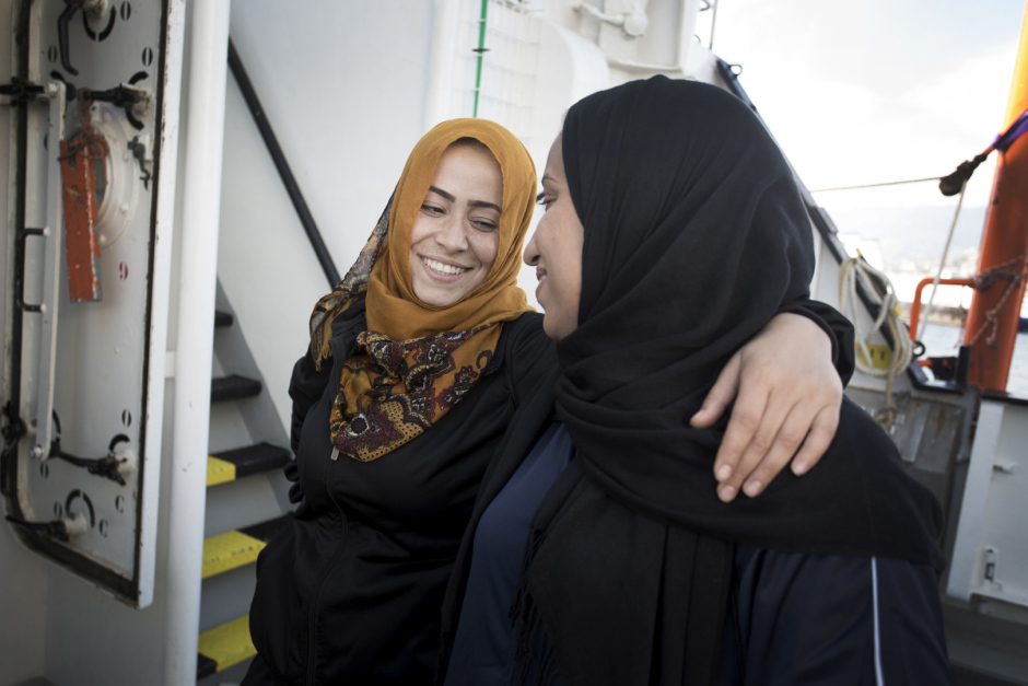 Italy, Messina, October 19th, 2017Hasna and Rajaa, 27 years old, both childhood friends, hugging each other a few minutes before arriving at Messina in Sicilia.Hasna and Rajaa are Maroccans and had left their country two years ago following the economic crisis. They went to find fortune in Lybia together. "But, in Lybia, there is no life : militias make life impossible to people We can't go buying some bred without being arrested and getting robbed some money, they can kill you for nothing. In addition, I was working as hairdresser and I earned very few. We had escaped murder but we have seen so many people getting shot in front of our eyes.There were explosions everywhere, somtimes we didn't eat for two day, you don't know if you're gonna live or not, so you don't care about anything... We just wanted to have a simple life, without being afraid of dying every night. So we decided to take the boat. Everybody talk about these boats... We got into it. We saw this mother with her two daughters. I cried, because they are boats of death...But if she leave, even with her little girls, if we are gone, if I left my 6-year-old daughter and left her to my mother, it's because we don't have other choice... We leave our families, our country, everything. Because life over there is just not possible anymore..."Italie, Messina, 19 octobre 2017Hasna et Rajaa, 27 ans toutes les deux et amies d?enfance, se serrent dans les bras quelques minutes avant de debarquer a Messina en Sicile. Hasna et Rajaa sont marocaines et ont quittÈ leur pays il y a deux ans suite ‡ la crise Èconomique. Elles sont allÈs chercher fortune en Libye ensemble. ?Mais en Libye il n?y a aucune vie : les milices rendent la vie impossible aux gens. On ne peut pas aller acheter du pain sans Ítre arrÍtÈes et se faire voler de l?argent, ils peuvent te tuer pour rien. En plus je travaillais comme coiffeuse et je gagnais trËs peu. On a ÈchappÈ au meurtre mais on a vu tellement de gens se faire abattr