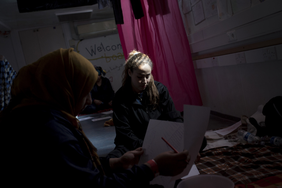 Mediterranean Sea, October 18th, 2017Hasna, 27, draws in the "shelter" of the Aquarius.Hasna is Maroccan and had left her country two years ago following the economic crisis. She went to find fortune in Lybia with her childhood friend Rajaa. "But, in Lybia, there is no life : militias make life impossible to people We can't go buying some bred without being arrested and getting robbed some money, they can kill you for nothing. In addition, I was working as hairdresser and I earned very few. We had escaped murder but we have seen so many people getting shot in front of our eyes.There were explosions everywhere, somtimes we didn't eat for two day, you don't know if you're gonna live or not, so you don't care about anything... We just wanted to have a simple life, without being afraid of dying every night. So we decided to take the boat. Everybody talk about these boats... We got into it. We saw this mother with her two daughters. I cried, because they are boats of death...But if she leave, even with her little girls, if we are gone, if I left my 6-year-old daughter and left her to my mother, it's because we don't have other choice... We leave our families, our country, everything. Because life over there is just not possible anymore..."Mer Méditerranée, 18 octobre 2017Hasna, 27, fait un dessin dans le “shelter” de l’Aquarius. Hasna est marocaine et a quitté son pays il y a deux ans suite à la crise économique. Elle est allée chercher fortune en Libye avec son amie d’enfance Rajaa. “Mais en Libye il n’y a aucune vie : les milices rendent la vie impossible aux gens. On ne peut pas aller acheter du pain sans être arrêtées et se faire voler de l’argent, ils peuvent te tuer pour rien. En plus je travaillais comme coiffeuse et je gagnais très peu. On a échappé au meurtre mais on a vu tellement de gens se faire abattre devant nos yeux.Il y avait des explosions de partout, parfois on ne mangeait pas pendant deux jours, tu sais plus si tu vas