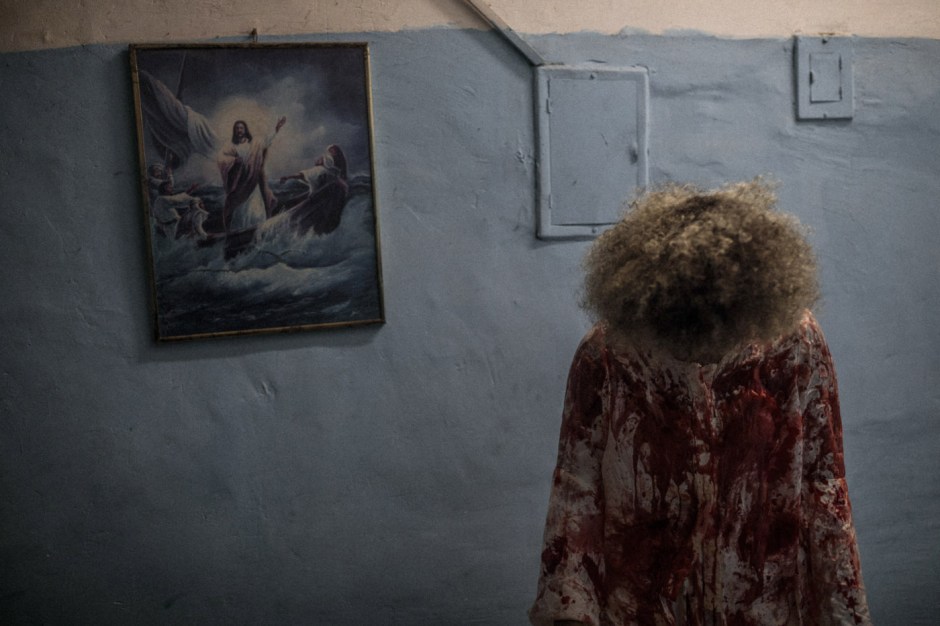 Brazil, Rio de Janeiro, March 30, 2018 - In the bowels of Brazilian inequality, in the difficulty of remembering our history, our origins, anomia generates the feeling of that « which must not be named ». It occurs when individuals feel pressured to violate norms. Woman stained with son's blood symbolizing Mary, mother of Jesus, cries during performance in favela Da Rocha.