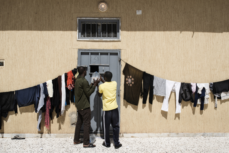 Libya, Garabulli, 28 March 2016About 400 people are in Al-Gweyah detention center. Prisoners are mainly sub-Saharan illegal migrants on the road to Europe. Beaches near Tripoli are the main departure points to cross Mediterranean Sea to Italy. Lot ot migrants try to work illegaly in Libya in order to pay the trip.Prisoners are passing water bottles into a cell. For security reasons, all prisoners are not allowed to go into the courtyard at the same time.Libye, Garabulli, 28 mars 2016Le centre de detention d'Al-Gweyah compte près de 400 détenus en situation irrégulière. Les prisonniers sont principalement des migrants subsahariens sans papiers en route pour l'Europe. Les plages à proximité de Tripoli sont un point de départ pour traverser la méditerranée vers l'Italie. Beaucoup de migrants tentent de travailler illégalement en Libye pour payer leur passage.Deux prisonniers font passer des bouteilles d'eau dans une cellule. Pour des raisons de place et de sécurité, les prisonniers ne sont pas autorisés à sortir dans la cour tous en même temps.Michael Zumstein / Agence VU