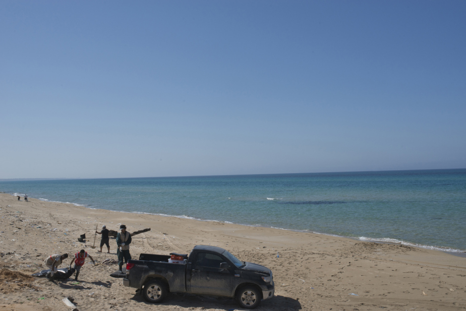 Libya, Castelverde, 29 March 2016On Garabulli's beach, 40 kilometres from Tripoli, members of the Libyan Red Crescent gather corpses from a migrants' boat which capsiezd few days ago.Members of the Libyan Red Crescent are carrying a migrant's dead body in a car.Libye, Gasr Garabulli, 29 mars 2016Sur la plage de Garabulli, à une quarantaine de kilometres de Tripoli, les membres du Croissant Rouge libyen ont été appelé pour ramasser les cadavres d'une embarcation de migrants ayant chaviré quelques jours plus tôt.Les membres du Croissant Rouge s'apprêtent à remonter le cadavre d'un migrant dans le véhicule d'un particulier.Michael Zumstein / Agence VU