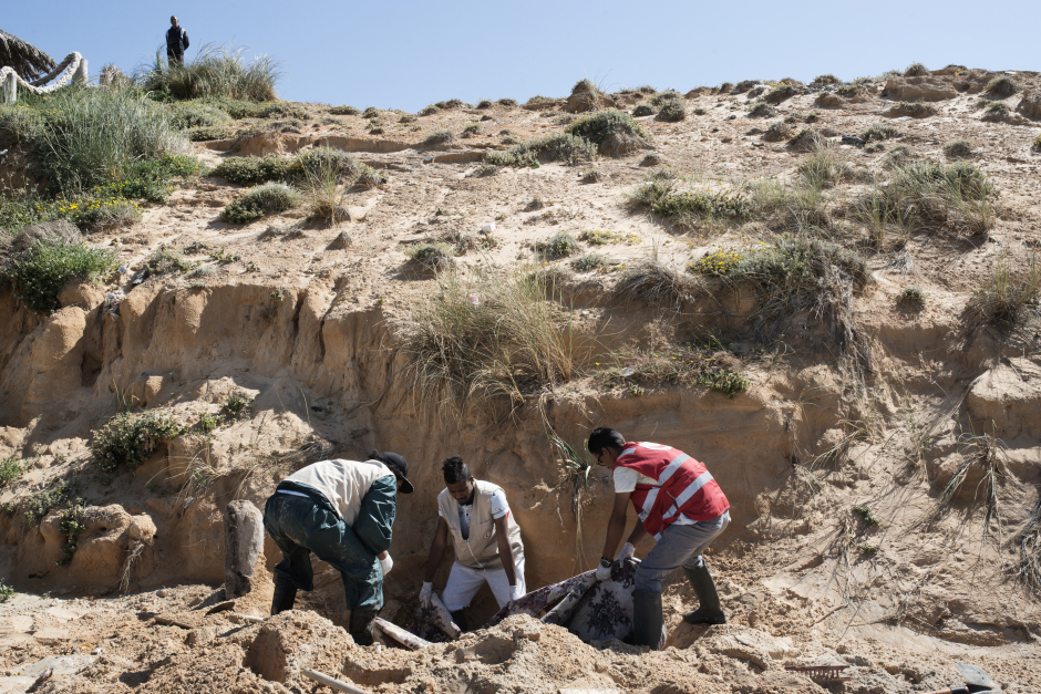 Libya, Castelverde, 29 March 2016On Garabulli's beach, 40 kilometres from Tripoli, members of the Libyan Red Crescent gather corpses from a migrants' boat which capsiezd few days ago.Members of the Libyan Red Crescent are taking a migrant's dead body, burried by the local population.Libye, Gasr Garabulli, 29 mars 2016Sur la plage de Garabulli, à une quarantaine de kilometres de Tripoli, les membres du Croissant Rouge libyen ont été appelé pour ramasser les cadavres d'une embarcation de migrants ayant chaviré quelques jours plus tôt.Les membres du Croisant Rouge sorte le cadavre d'un migrant ayant été enterré par la population locale.Michael Zumstein / Agence VU