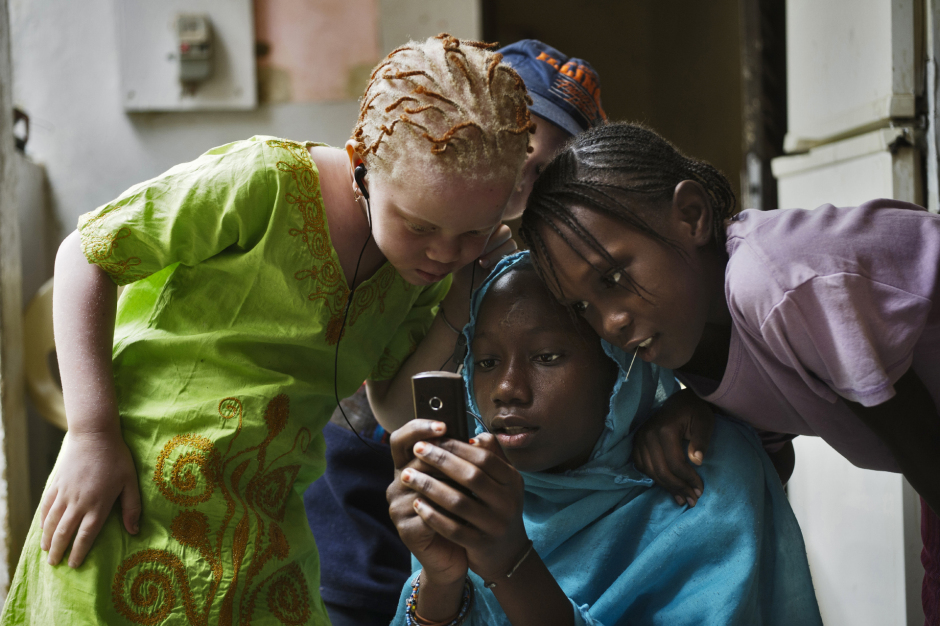 Senegal, Thiès, 28 March 2012Fabimeta Diop (in green), daughter of Mohamadou Bamba Diop, president of the National Association of Albinos from Senegal (ANAS), listening music with her friends.Sénégal, Thiès, 28 mars 2012Fabimeta Diop (en vert), la fille de Mohamadou Bamba Diop, président de l'Association Nationale des Albinos du Sénégal (ANAS), écoute de la musique avec ses camarades.Michael Zumstein / Agence VU