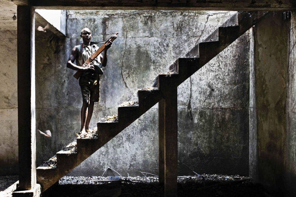 Central African Republic, Berengo, 26 January 2014In the former residency of Emperor Jean Bedel Bokassa constently looted since 1996, young recruits, abandonned by the Seleka during their training, are waiting to join the regular army.  A young man is posing with a wooden weapon.République Centrafricaine, Berengo, 26 Janvier 2014Dans l'ancienne résidence de l'empereur Jean Bedel Bokassa, pillée depuis 1996, des jeunes recrues, abandonnés par la Seleka pendant leur formation, attendent leur réintégration dans une future armée régulière. Un jeune homme pose avec une arme en bois.Michael Zumstein / Agence VU