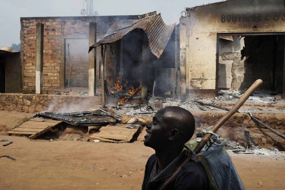 Central African Republic, Bangui, 22 January 2014At the Kilometre Point 13 (PK13), inhabitants of the district, helped by anti-balakas militiamen, have looted and burnt the entire district of Bégoua.A young man, happy about the looting, is passing in front of a burning shop owned by a Muslim shopkeeper.République Centrafricaine, Bangui, 22 Janvier 2014Au point kilométrique 13 (PK 13), des habitants du quartier, aidés par des miliciens anti-Balaka, ont pillé et detruit la totalité du quartier de Bégoua.Un jeune homme se réjouissant de son pillage, passe devant la boutique en feu d'un commerçant musulman.Michael Zumstein / Agence VU